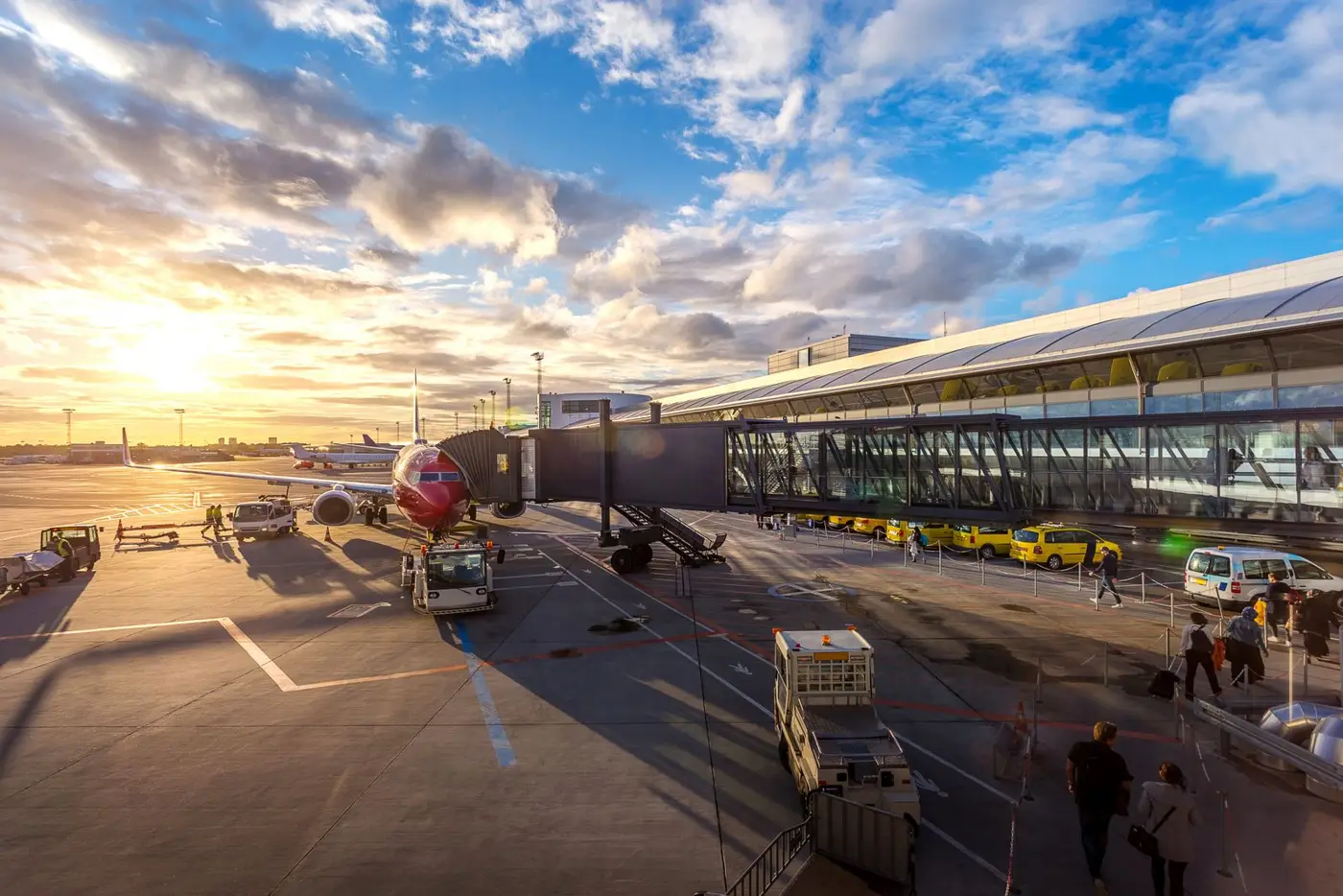 Travellers at an airport terminal with a plane outside